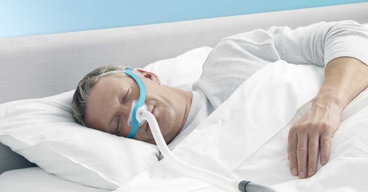 man in bed wearing the evora nasal mask