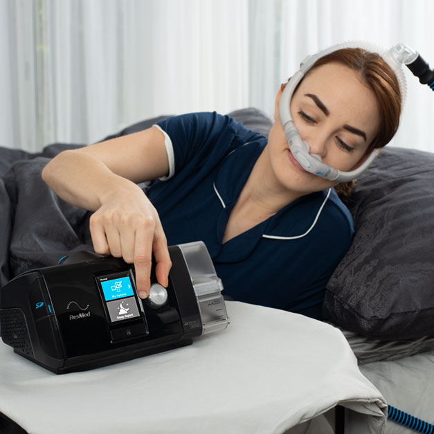 woman adjusting the settings on her Resmed Airsense