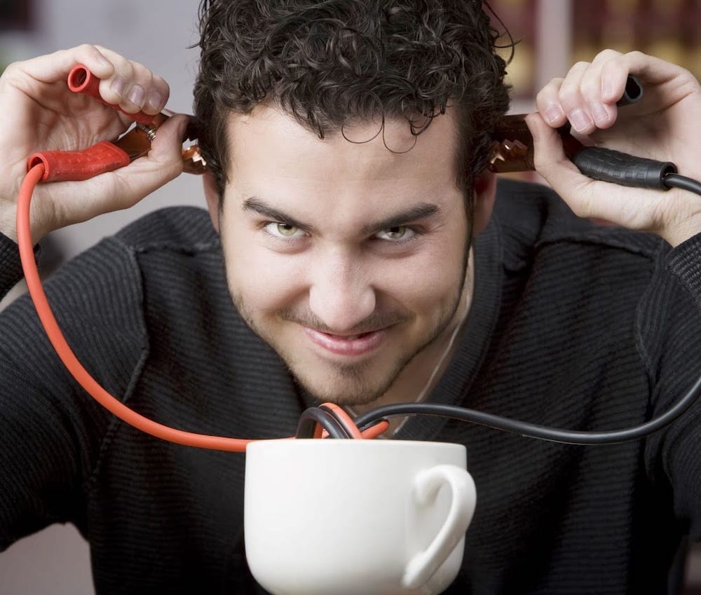 man with jumper cables and a cup of coffee