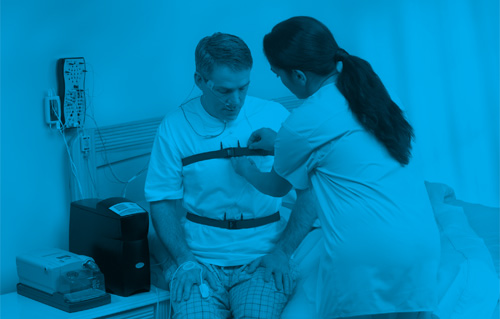 Nurse helping patient with in-lab sleep testing equipment